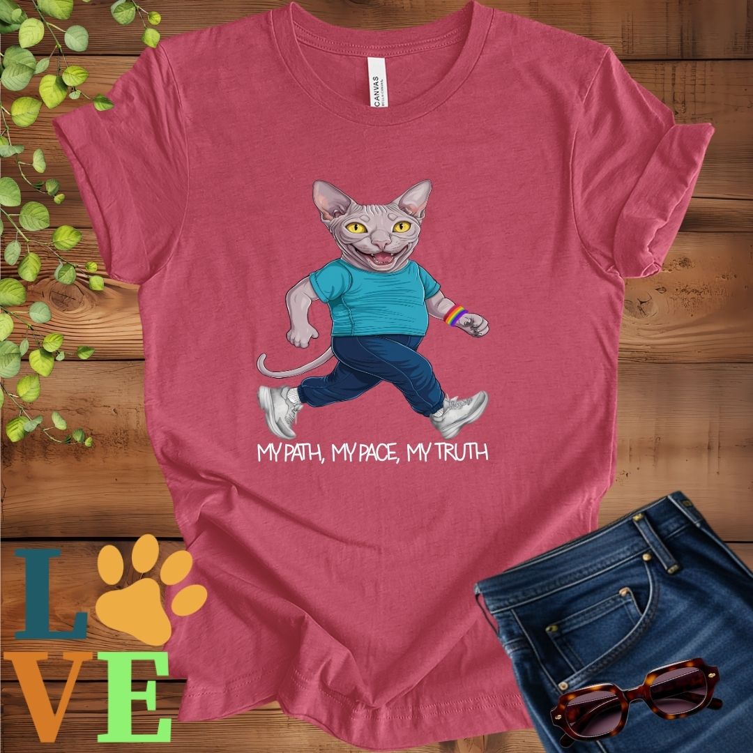 Muted raspberry pink (heather raspberry) t-shirt featuring an anthropomorphic Sphynx cat in exercise wear walking confidently with the slogan, "My path, my pace, my truth."

