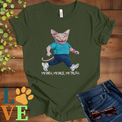 Olive green (military green) t-shirt featuring an anthropomorphic Sphynx cat in exercise wear walking confidently with the slogan, "My path, my pace, my truth."
