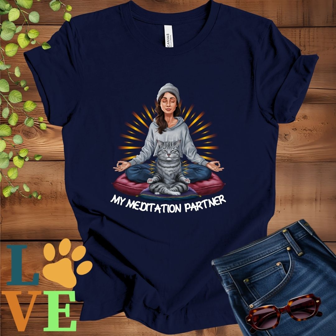 Navy blue t-shirt featuring a woman meditating with her tabby cat and the slogan "My meditation partner".