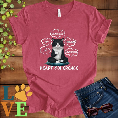 Muted raspberry pink (heather raspberry) t-shirt with a meditating tuxedo cat, surrounded by floating emotion bubbles labelled love, joy, gratitude, freedom, abundance, and 'Heart Coherence' slogan.