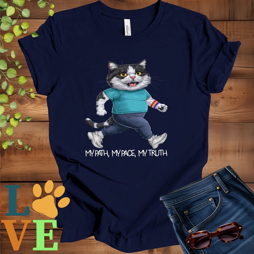 Navy blue t-shirt featuring an anthropomorphic tuxedo cat in exercise wear walking confidently with the slogan, "My path, my pace, my truth."
